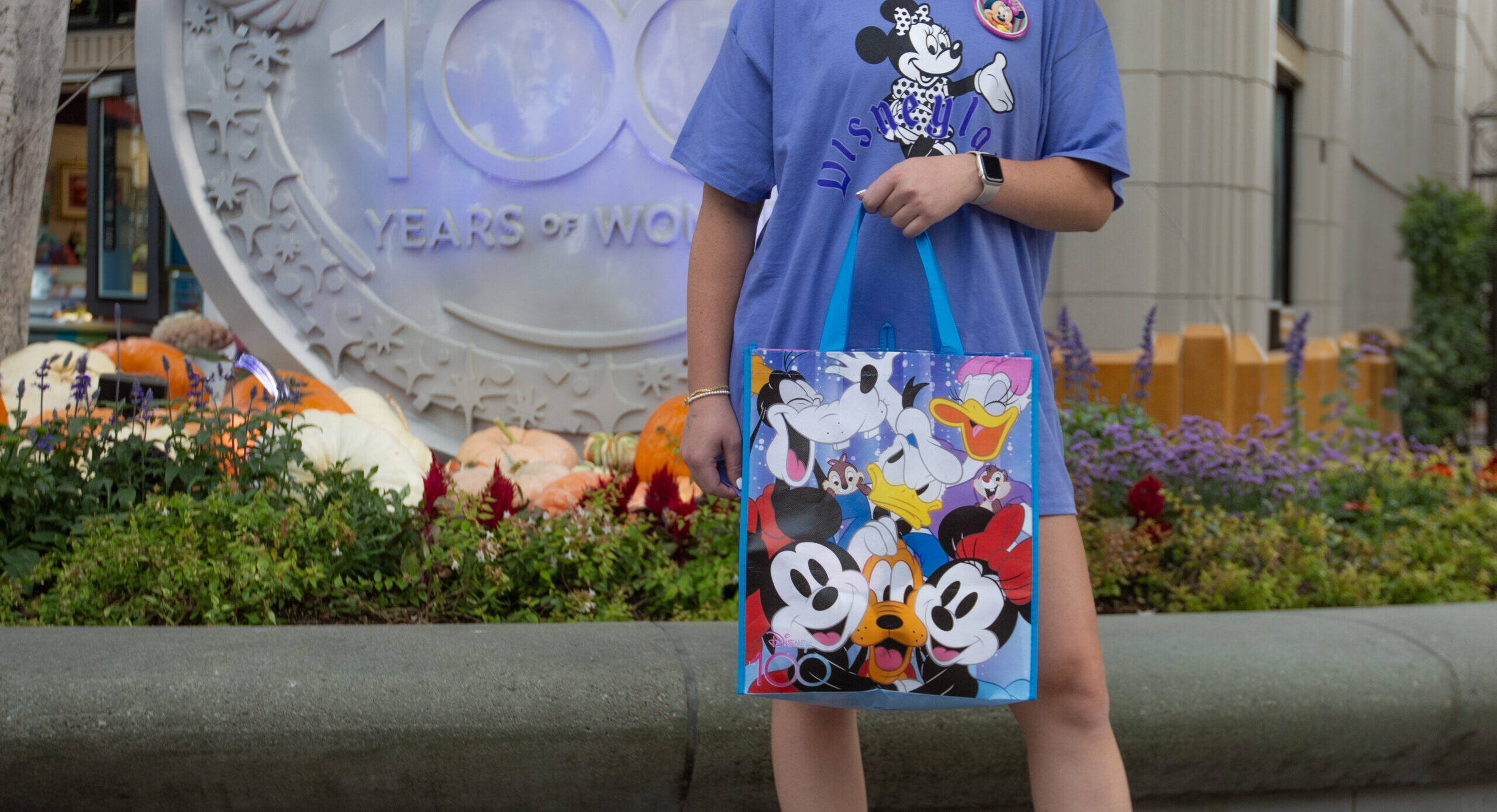 Woman holding a Disney 100 tote bag at Disney Land